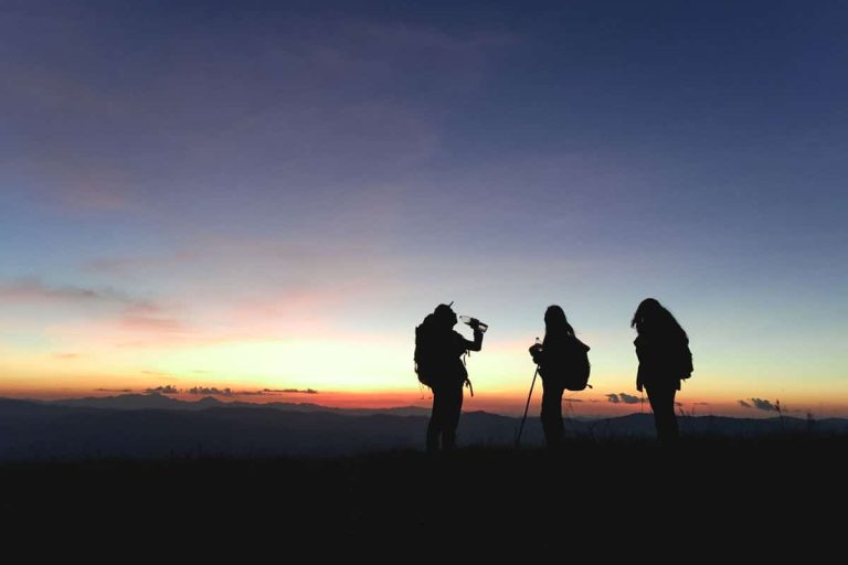 Silhouettes of group hikers people with backpacks enjoying